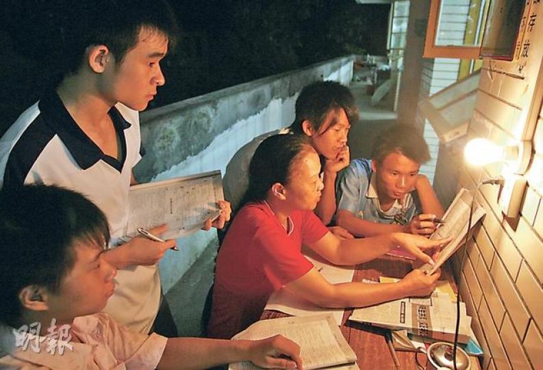 廣西藤縣學生晚上有自習堂，幾個人靠一盞昏黃的電燈泡作照明，看課本教材研習。（陳莊勤攝）