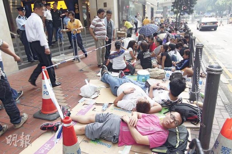 今次iPhone 5開售，蘋果專門店只接受網上預訂，故國金二期旗艦店昨日不見人龍。不過，銅鑼灣一家特許經銷店外前日開始出現人龍，當中不乏疑為「排隊黨」的南亞裔人，排頭的買家一連兩晚躺在馬路邊露宿（圖）。（郭慶輝攝） 旺角先達廣場多間商舖都貼出「收機」告示。有手機店負責人表示已收到數十人預訂，全為內地人，預料首批新機今日的收購價約為8000元，出售價約為8500元至1.2萬元。（劉焌陶攝）