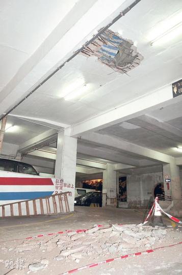 元朗一個停車場的主要行車通道昨「塌石屎」，天花大幅石屎剝落，露出5呎乘5呎「大窿」及生鏽鋼筋，數百車輛被困，不准駛離現場。（衛永康攝）