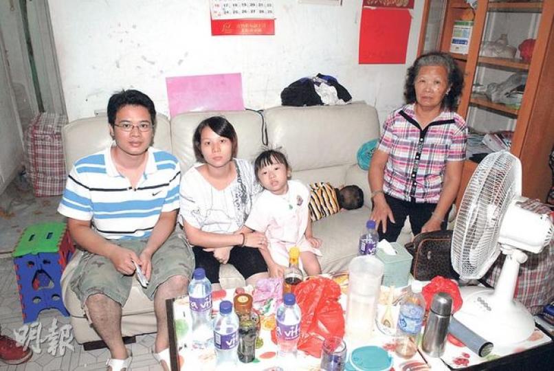 何先生（左）一家五口雖收入微薄，但自食其力，然而在妻子（左二）再度懷孕之際，卻面臨執達吏收地，一家前路茫茫。（伍浦鋒攝） 何家兩代在圖中簡陋鐵皮屋生活逾40年，指屋外果樹不時「幫補伙食」，一家貧亦樂，但執達吏堅持下月8日是收地最後期限，何家現只望能獲恩恤編配公屋。（伍浦鋒攝）