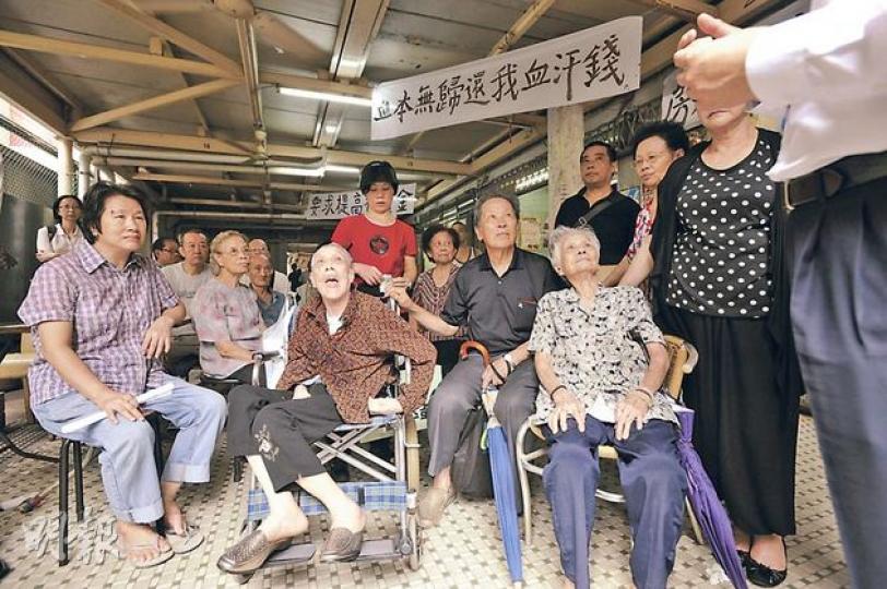 東頭邨22座的商戶大部分年過70，最年長是95歲的朱婆婆（前排右一），他們昨日集合一起抗拒房署收樓。（葉家豪攝） 經營藥行逾30年的張婆婆表示，前日接連收到房署3個電話，又有職員哄她先交出鑰匙，再討論賠償。（葉家豪攝）