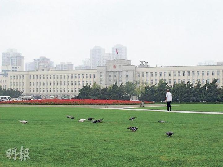 薄熙來在大連的一大政績就是「種草」改善環境，現時大連仍四處綠草如茵，有市民感慨今不如昔。圖為大連市政府前的廣場。（明報記者攝）（明報製圖）