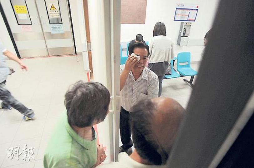 在秀茂坪倫常慘案中，女死者父親（抹淚者）到醫院時驚聞慘劇，與男死者父母（禿頭及綠衣者）談起情况，痛哭流淚。（樊銳昌攝）