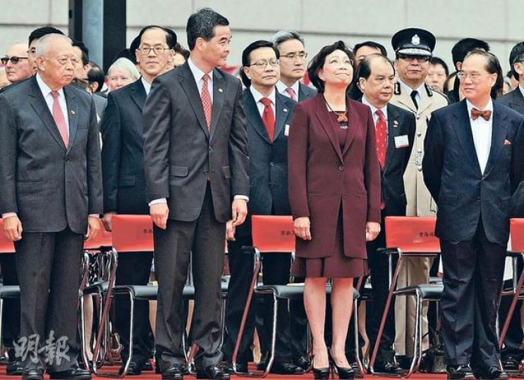 灣仔金紫荊廣場國慶升旗禮，三代特首同場出現。第一代特首董建華（前排左一）與新任特首梁振英（前排左二）服飾一致，西裝左邊胸口掛上國旗及區旗小襟章，第二代特首曾蔭權（前排右一）仍一貫煲呔裝，西裝放袋巾。梁與曾對目而視打了個招呼，中間隔了梁太唐青儀（前排右二）。（劉焌陶攝）