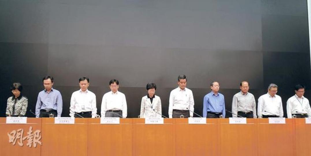 特首梁振英（右五）與另外9名與事件相關的高級官員，昨午舉行聯合記者會前為死難者默哀1分鐘。新聞處亦特別用黑色紙張，遮蓋記者室內維港夜景的布景。（劉焌陶攝）