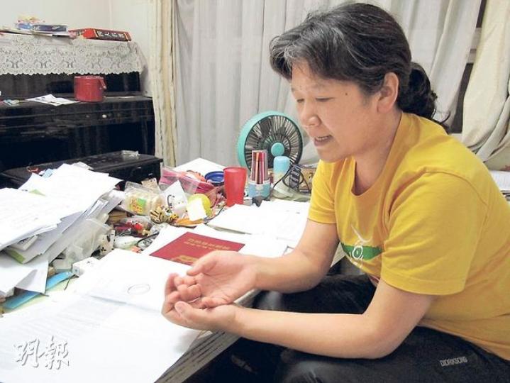 王彥霞（圖）家中堆滿案件資料，現時業權已強制過戶，她擔心自己和幼女無家可歸。她把經歷寫入電影《最長的擁抱》，將在全國公映，上圖為電影海報。（明報記者攝）