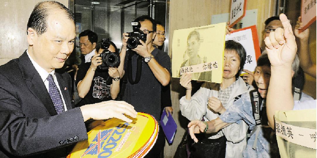「爭取全民退休保障聯席」昨日趁政府公布長者生活津貼計劃，向勞工及福利局長張建宗（左）抗議，要求津貼不設入息資產申報。（劉焌陶攝）