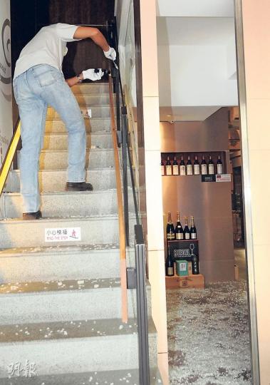 探員在通往1樓髮型屋樓梯蒐證，地下滿佈玻璃碎片。（蔡方山攝）酒窖負責人表示，疑賊人「不識貨」，故未有偷去近入口位置的名酒（圖），只盜走兩個同類酒辦空樽。（蔡方山攝）