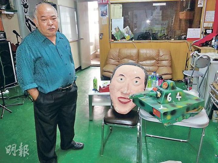 「阿牛」曾健成在被他形容為「反共基地」的民間電台總部,展視他的「勞作」,包括以發泡膠手雕的唐英年人頭,以及用紙皮製的坦克車。自小喜歡美術的阿牛坦言,一向作風「浪漫」,中學時向同學派的聖誕卡都是由他親手畫。(林凱旻攝) 「阿牛」曾健成在被他形容為「反共基地」的民間電台總部,展視他的「勞作」,包括以發泡膠手雕的唐英年人頭,以及用紙皮製的坦克車。自小喜歡美術的阿牛坦言,一向作風「浪漫」,中學時向同學派的聖誕卡都是由他親手畫。(林凱旻攝)