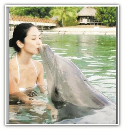 楊采妮在水中跟海豚親吻,畫面非常可愛溫馨。(微博圖片) 楊采妮在水中跟海豚親吻,畫面非常可愛溫馨。(微博圖片)
