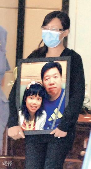 南丫島39死海難中雙雙遇難的港燈工程師徐志偉及徐凱盈父女昨日舉殯,徐妻強忍悲痛,抱着丈夫及女兒生前合照,陪同靈柩登上靈車往火葬場。(雲錦鋒攝) 南丫島39死海難中雙雙遇難的港燈工程師徐志偉及徐凱盈父女昨日舉殯,徐妻強忍悲痛,抱着丈夫及女兒生前合照,陪同靈柩登上靈車往火葬場。(雲錦鋒攝)