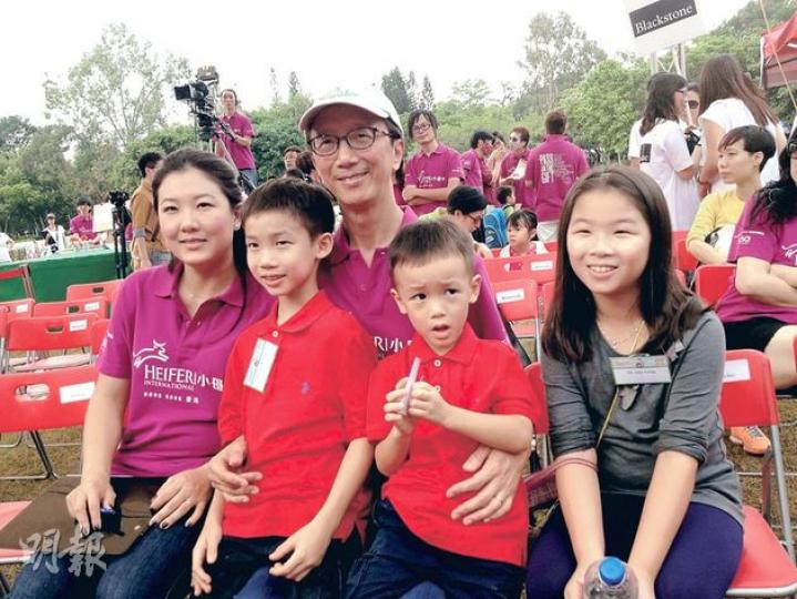 前財政司長梁錦松（戴帽者）昨偕妻、奧運跳水金牌選手伏明霞（左）和兩子一女出席小母牛活動，開腔力撐長者生活津貼設資產申報，說此政策是為扶貧，即幫助有需要的人，故設申報做法恰當。（陳洛明攝）