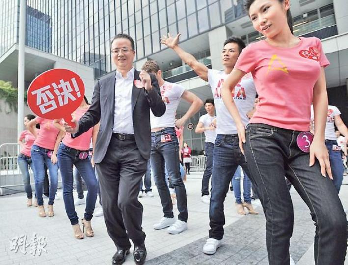 亞洲電視投資者王征(前左)昨日全程手舉「否決」紙牌。於眾亞姐及藝員綵排期間,他更突然站於眾藝員前「領舞」,大跳「江南Style」。(葉家豪攝)立法會議員毛孟靜(左下角)走進集會現場,欲與王征(右上角)對話,二人隔着亞洲先生候選人的人牆起爭執,其間王征更叫毛「滾回去」。(盧翊銘攝)一眾員工出席亞視的反對濫發牌照集會,有員工更帶同子女出席,並表示讓他們來「見識吓」,眾人須負責高舉示威牌。(盧翊銘攝) 亞洲電視投資者王征(前左)昨日全程手舉「否決」紙牌。於眾亞姐及藝員綵排期間,他更突然站於眾藝員前「領舞」,大跳「江南Style」。(葉家豪攝)立法會議員毛孟靜(左下角)走進集會現場,欲與王征(右上角)對話,二人隔着亞洲先生候選人的人牆起爭執,其間王征更叫毛「滾回去」。(盧翊銘攝)一眾員工出席亞視的反對濫發牌照集會,有員工更帶同子女出席,並表示讓他們來「見識吓」,眾人須負責高舉示威牌。(盧翊銘攝)