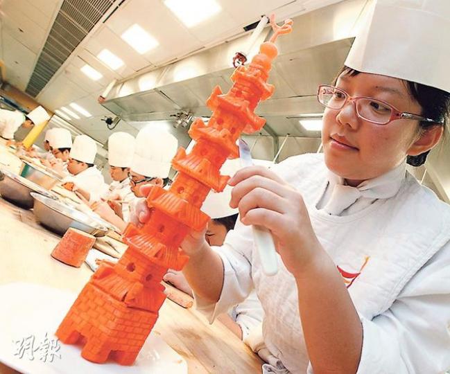 中廚學生鄺穎琪話,呢個就係為菜式「雁塔題名」所雕嘅裝飾甘筍塔,每個要花兩小時。(李紹昌攝) 中廚學生鄺穎琪話,呢個就係為菜式「雁塔題名」所雕嘅裝飾甘筍塔,每個要花兩小時。(李紹昌攝)