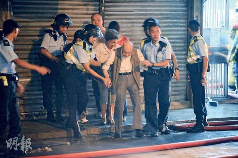火警中,有年邁行動不便的居民要由警員攙扶協助疏散到樓下安全地方。(樊銳昌攝)鰂魚涌中興大廈昨晚發生四級火警,因火屑波及外牆棚架圍網,一度有數個單位同時起火焚燒,消防將火警升至四級,要不斷射水灌救,幸未有釀成嚴重傷亡。(樊銳昌攝) 火警中,有年邁行動不便的居民要由警員攙扶協助疏散到樓下安全地方。(樊銳昌攝)鰂魚涌中興大廈昨晚發生四級火警,因火屑波及外牆棚架圍網,一度有數個單位同時起火焚燒,消防將火警升至四級,要不斷射水灌救,幸未有釀成嚴重傷亡。(樊銳昌攝)