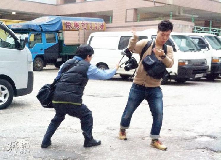 涉偽造遺囑的大律師黃桂生(左)離開法院時被記者追訪,走至停車場時突然轉身,對《星島日報》攝影記者又踢又打,更拉扯該記者的相機。(余卓善攝) 涉偽造遺囑的大律師黃桂生(左)離開法院時被記者追訪,走至停車場時突然轉身,對《星島日報》攝影記者又踢又打,更拉扯該記者的相機。(余卓善攝)