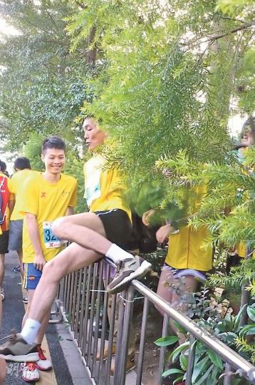 不少跑手為求盡快起步,跨越鐵馬。(楊歡攝) 不少跑手為求盡快起步,跨越鐵馬。(楊歡攝)