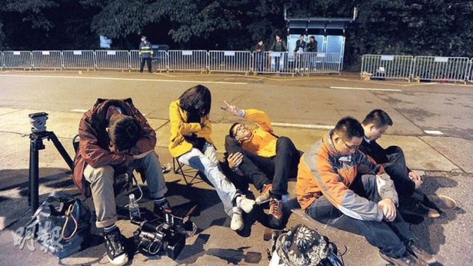 約50名記者前晚在澳門路環監獄外「又濕又冷」的環境下通宵等候尹國駒出獄,不少記者最後倦得坐在地上,不管地面濕滑。(余俊亮攝) 約50名記者前晚在澳門路環監獄外「又濕又冷」的環境下通宵等候尹國駒出獄,不少記者最後倦得坐在地上,不管地面濕滑。(余俊亮攝)
