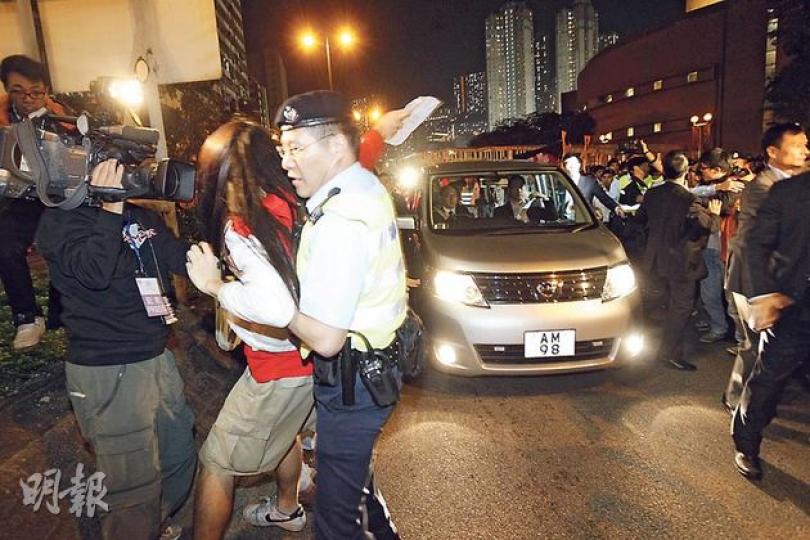 梁振英離開時,座駕突圍而出,但仍有社民連示威者衝出,要由警員拉開阻止,車輛才能駛出。(郭慶輝攝)特首梁振英及官員出席地區諮詢會後遭數十人狙擊。他從葵青劇院後門乘車離開,由近50名警員築人鏈開路,惟黃洋達衝在車前倒地阻路,梁的座駕要由警員護駕後倒車近50米,才能繞道離開。(郭慶輝攝) 梁振英離開時,座駕突圍而出,但仍有社民連示威者衝出,要由警員拉開阻止,車輛才能駛出。(郭慶輝攝)特首梁振英及官員出席地區諮詢會後遭數十人狙擊。他從葵青劇院後門乘車離開,由近50名警員築人鏈開路,惟黃洋達衝在車前倒地阻路,梁的座駕要由警員護駕後倒車近50米,才能繞道離開。(郭慶輝攝)