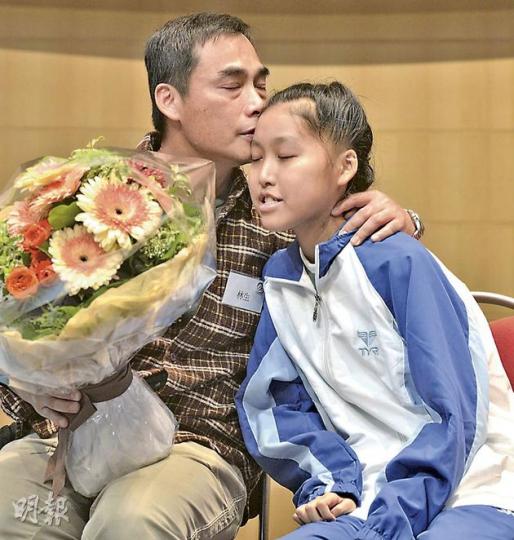 早前接受心臟移植手術的「小飛魚」林言臻(右)昨日向父母獻花,感謝兩人照顧,言臻爸爸(左)難掩喜悅,輕吻女兒。言臻這數個月來瘦了數十磅。(鄧宗弘攝) 早前接受心臟移植手術的「小飛魚」林言臻(右)昨日向父母獻花,感謝兩人照顧,言臻爸爸(左)難掩喜悅,輕吻女兒。言臻這數個月來瘦了數十磅。(鄧宗弘攝)