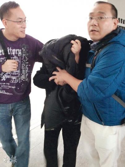涉案警署女文書助理(中),昨於親友掩護下離開高等法院。(黃建邦攝) 涉案警署女文書助理(中),昨於親友掩護下離開高等法院。(黃建邦攝)
