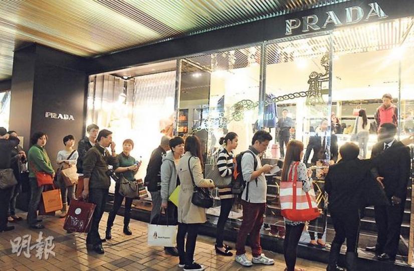 尖沙嘴廣東道名店街，今年夏天一度消失的購物人龍，臨近聖誕節再度重現，圖為昨天傍晚廣東道PRADA分店前的人龍。（劉焌陶攝）來自東北吉林的韓先生和幾位朋友首次赴港過聖誕，昨晚購物已花費數萬元。他們會逗留到聖誕節後，等節後商家有更多減價促銷活動，再加碼消費。（劉焌陶攝）來自重慶的向女士參加旅行團赴港，希望購入高檔奢侈品。由於旅行團不安排團友集體去高檔商場購物，她回到酒店之後獨自出來，到海港城消費，預期花費數萬元。（劉焌陶攝）