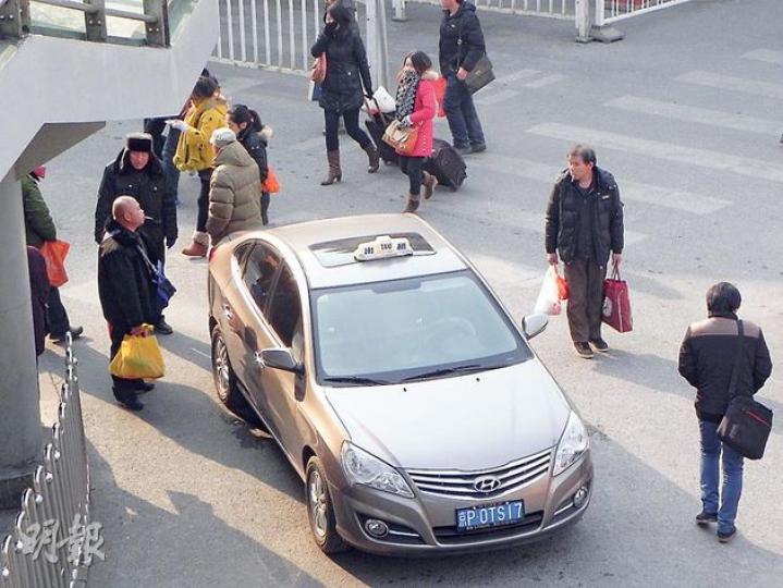北京西站北廣場路邊泊有的士,司機向從高鐵站出來想轉駁地鐵的乘客索價80元人民幣。(明報記者攝) 北京西站北廣場路邊泊有的士,司機向從高鐵站出來想轉駁地鐵的乘客索價80元人民幣。(明報記者攝)