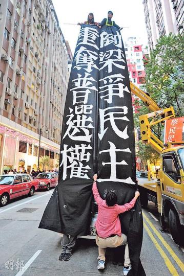 學民思潮成員黃之鋒(高空右)及周庭(高空左)冒着寒風企在吊臂車上,拉起「倒梁」橫額,呼籲港人參與元旦大遊行。 (尹錦恩攝) 學民思潮成員黃之鋒(高空右)及周庭(高空左)冒着寒風企在吊臂車上,拉起「倒梁」橫額,呼籲港人參與元旦大遊行。 (尹錦恩攝)