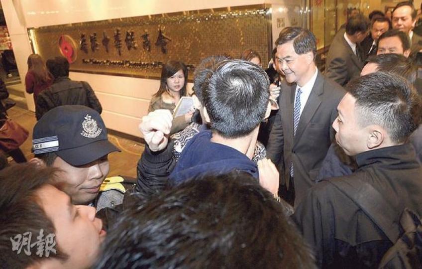 特首梁振英(右結領帶者)昨晚出席建制派議員飯局時,於會場外遇到示威者(左下角),大批保安在場戒備。(余俊亮攝) 特首梁振英(右結領帶者)昨晚出席建制派議員飯局時,於會場外遇到示威者(左下角),大批保安在場戒備。(余俊亮攝)