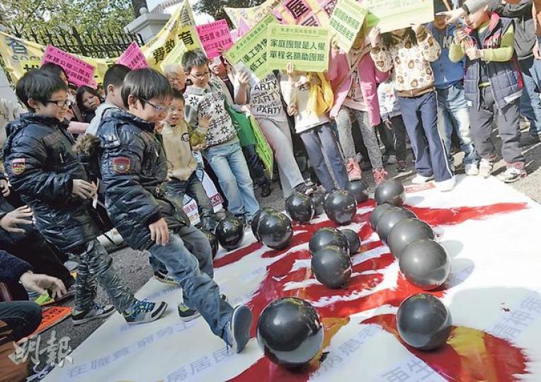 逾200名市民昨早由舊政府總部遊行到禮賓府請願,要求《施政報告》制訂長遠扶貧措施,多名小童即場踏破18個寫上「貧」字的黑色氣球,象徵政府要做好18區滅貧工作。(余俊亮攝) 逾200名市民昨早由舊政府總部遊行到禮賓府請願,要求《施政報告》制訂長遠扶貧措施,多名小童即場踏破18個寫上「貧」字的黑色氣球,象徵政府要做好18區滅貧工作。(余俊亮攝)