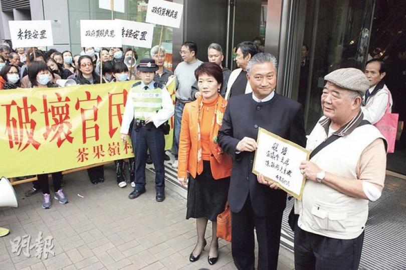 觀塘區議會昨討論前茶果嶺高嶺土礦場地皮的規劃方案。約800名茶果嶺村村民到場示威,批評方案需遷拆村內祖墳,未有諮詢村民,村長邱東(右一)向觀塘區議會主席陳振彬(右二)提交請願信。(黃俊鋒攝) 觀塘區議會昨討論前茶果嶺高嶺土礦場地皮的規劃方案。約800名茶果嶺村村民到場示威,批評方案需遷拆村內祖墳,未有諮詢村民,村長邱東(右一)向觀塘區議會主席陳振彬(右二)提交請願信。(黃俊鋒攝)