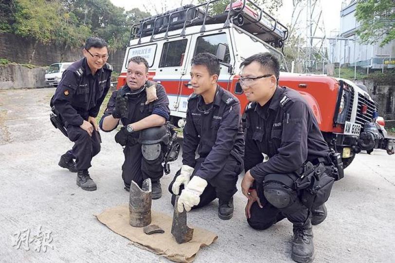 警方爆炸品處理組專家將被發現的戰時炮彈引爆後,檢走炮彈碎片作進一步處理。(樊銳昌攝) 警方爆炸品處理組專家將被發現的戰時炮彈引爆後,檢走炮彈碎片作進一步處理。(樊銳昌攝)