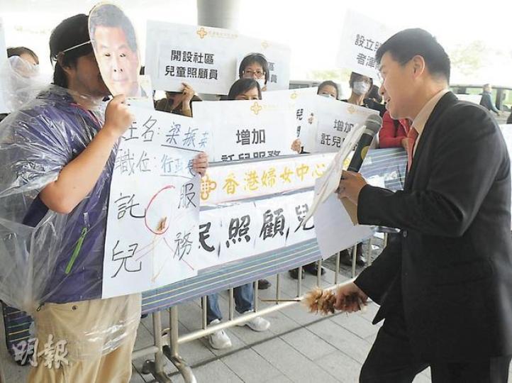 立法會內昨日起一連3日辯論施政報告致謝動議,場外有不少團體請願,有婦女中心投訴政府提供的託兒服務不足,要求開設社區兒童照顧員職位,議員范國威(右)拿着雞毛掃,打「梁振英」屁股,寓意梁振英做得不夠好要被懲罰。(劉焌陶攝) 立法會內昨日起一連3日辯論施政報告致謝動議,場外有不少團體請願,有婦女中心投訴政府提供的託兒服務不足,要求開設社區兒童照顧員職位,議員范國威(右)拿着雞毛掃,打「梁振英」屁股,寓意梁振英做得不夠好要被懲罰。(劉焌陶攝)