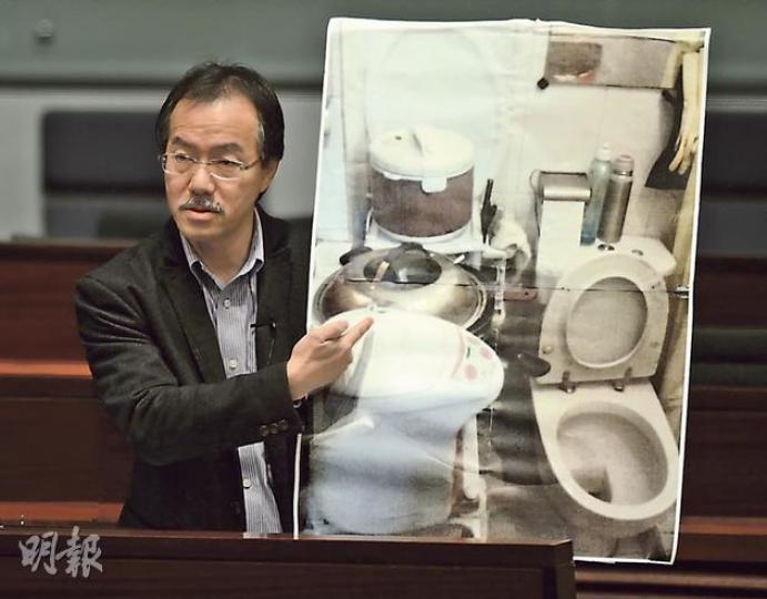 工黨張超雄指劏房生活環境惡劣，以大相展示劏房的洗手間也要用來放置電飯煲、熱水瓶等電器。（余俊亮攝）