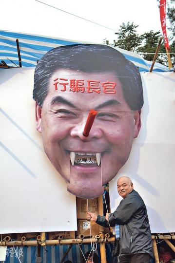 社民連攤位整咗個巨型梁振英布景,唔止個鼻會伸長,就連個嘴都郁得,一拉就會伸出「你呃人」三隻字,「阿牛」曾健成仲親身示範(圖),睇嚟社民連嘅勞作技術真係愈來愈出神入化。(曾安迪攝) 社民連攤位整咗個巨型梁振英布景,唔止個鼻會伸長,就連個嘴都郁得,一拉就會伸出「你呃人」三隻字,「阿牛」曾健成仲親身示範(圖),睇嚟社民連嘅勞作技術真係愈來愈出神入化。(曾安迪攝)