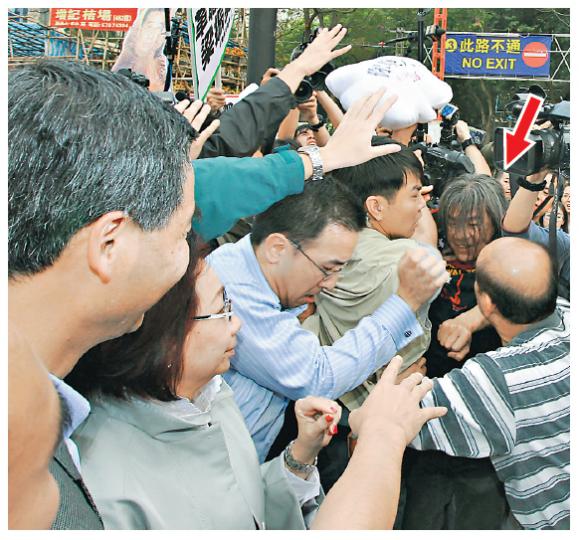 特首梁振英夫婦（左一、二）昨日逛維園年宵市場時遇到激烈示威。二人選購富貴燈籠竹期間，立法會議員梁國雄（箭嘴示）試圖向梁振英投擲印有「你呃人」字樣的咕