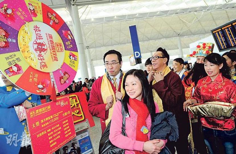不少新春旅行團昨大年初一起程,康泰旅行社董事總經理黃進達(左一戴黃圍巾者)到機場向旅客派外幣利市。(尹錦恩攝) 不少新春旅行團昨大年初一起程,康泰旅行社董事總經理黃進達(左一戴黃圍巾者)到機場向旅客派外幣利市。(尹錦恩攝)