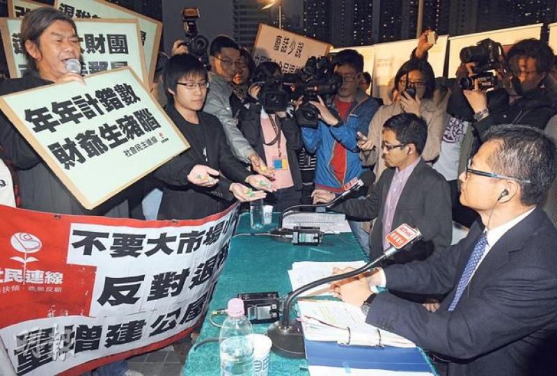 社民連梁國雄(左一)昨晚趁發展局長陳茂波(右一)到黃大仙廣場出席港台節目《自由風自由PHONE》時示威,送紙星星給他,諷刺財政司長曾俊華在預算案提及的「遙望繁星」。(劉焌陶攝) 社民連梁國雄(左一)昨晚趁發展局長陳茂波(右一)到黃大仙廣場出席港台節目《自由風自由PHONE》時示威,送紙星星給他,諷刺財政司長曾俊華在預算案提及的「遙望繁星」。(劉焌陶攝)