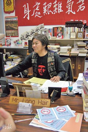「長毛」梁國雄（圖）無招呼衛生署控煙辦職員，啲職員擺低「嚴禁吸煙」標示同海報（圖下方）就走咗。（林景輝攝）