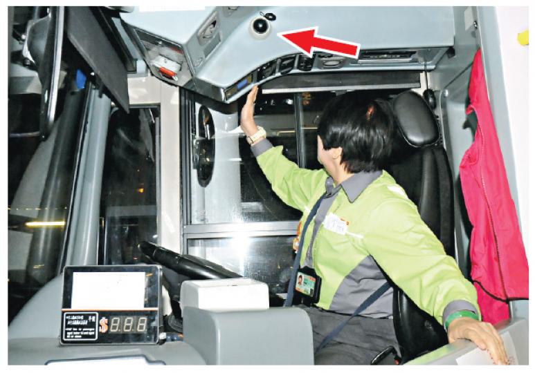 九巴引入的新巴士在司機位上方安裝錄影鏡頭（箭嘴示），向下攝錄司機而非拍攝路面情况，有女司機擔心會誤被拍下走光照。車長陳先生則認為鏡頭有時候助解決與乘客糾紛，但希望公司盡早解釋錄影用途及範圍，以免車長「估估下」。（劉焌陶攝）