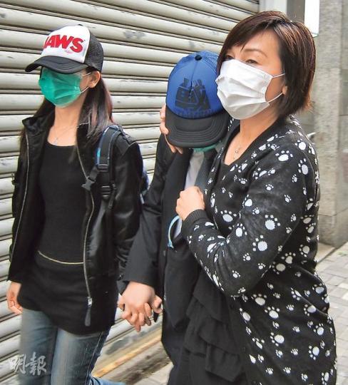 被告李啟燦（中）昨在兩名女親友陪同下，一同急步離開法院，其間李與其中一名女親友十指緊扣。（林綺琪攝）