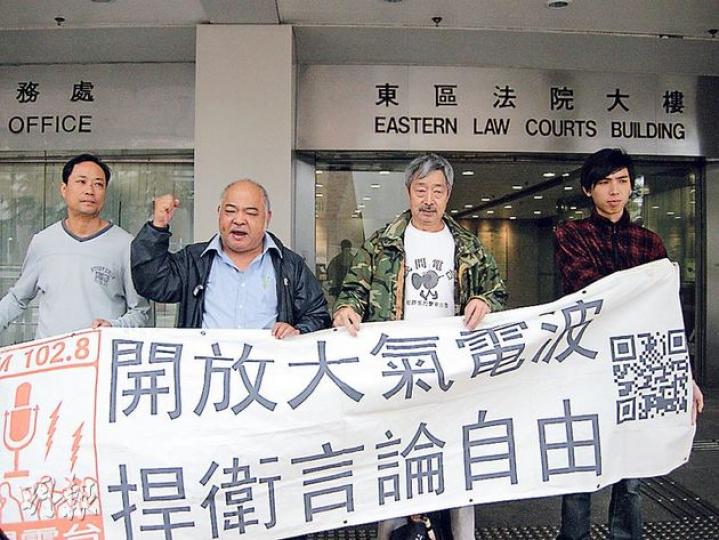 民間電台被指非法廣播,電台嘅其中3個經營者﹕台長曾健成(左二)、柯華冰(左一)同羅堪就(左三),噚日到東區裁判法院應訊,仲喺庭外同支持者高呼「開放大氣電波」。(黃建邦攝) 民間電台被指非法廣播,電台嘅其中3個經營者﹕台長曾健成(左二)、柯華冰(左一)同羅堪就(左三),噚日到東區裁判法院應訊,仲喺庭外同支持者高呼「開放大氣電波」。(黃建邦攝)
