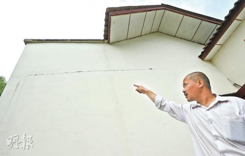 陳顯良向記者指示在地震後入住的新屋出現的裂縫，他對此很是擔心。（余俊亮攝）陳顯良（右）手捧2008年遇難兒子陳雨的遺照，他說和妻子及手抱的孩子（左）一家三口又回到5年前的恐慌狀態，只敢住在樓下。（余俊亮攝）