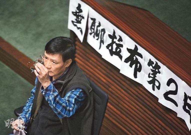 工聯會王國興昨繼續在會議期間寫大字發泄對議員拉布的不滿，並將大字報貼滿會議廳，包括寫有「無聊拉布第2日，浪費200萬公帑」及「四人拉布，市民找數」等。（盧翊銘攝）財經事務及庫務局長陳家強（左）昨早9時起在立法會坐鎮。他批評發動拉布的議員透過不斷要求點算人數，令會議停頓，重申財政預算案影響深遠，若未能及時審議，會令很多政府支出、社會和福利支出受影響。 （盧翊銘攝）