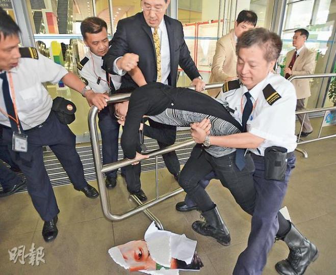 城大承認聘請「信和」的外判保安，外判保安公司董事便是前高級助理警務處長傅俊康（黃領呔穿西裝者）。學生衝擊時，傅亦出手護欄。（盧翊銘攝）城大學生會內務副會長梁迦南（箭嘴示）在場內向特首梁振英（紅色領呔者）遞信，一度被保安阻止，最終梁主動上前接信。（盧翊銘攝）梁振英在會場內致辭期間，示威大學生越過防線走到演講廳外門前。保安一度以「門已鎖上」為由，不讓記者離場採訪，引起記者不滿。    （盧翊銘攝）