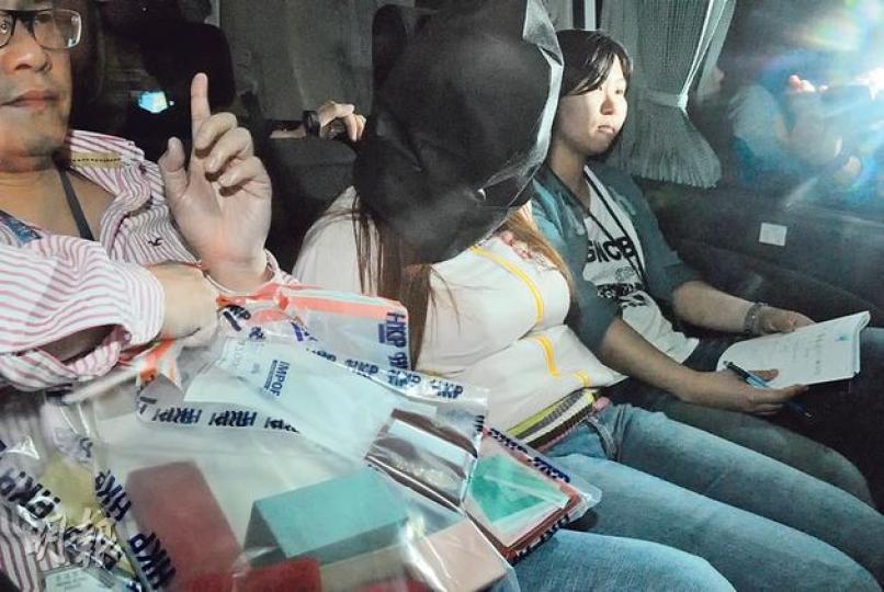 涉嫌與男友人清洗1.7億元黑錢的女子（蒙頭者），被警方從將軍澳天晉寓所拘捕，警並檢走一批證物帶署。（雲錦鋒攝）警方在涉嫌洗黑錢男女的寓所，搜出大量金銀珠寶，另有樓契等。（伍浦鋒攝）