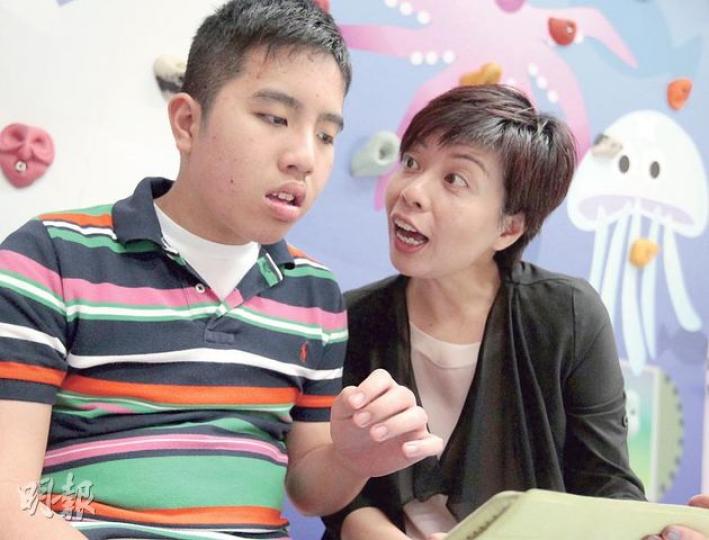 患有自閉症及中度智障的俊彥（左），語言表達能力不足，媽媽馮陳文娟（右）會借助電腦程式，讓孩子借圖像「發聲」，加強溝通。（郭慶輝攝）