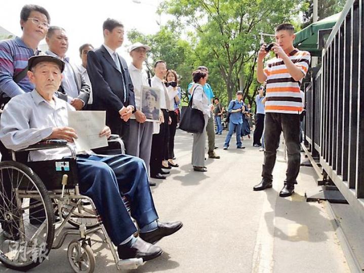 中國勞工代表張士傑(圖左坐輪椅者)在日本使館門口準備遞交致日本首相安倍的信函。(楊歡攝) 中國勞工代表張士傑(圖左坐輪椅者)在日本使館門口準備遞交致日本首相安倍的信函。(楊歡攝)