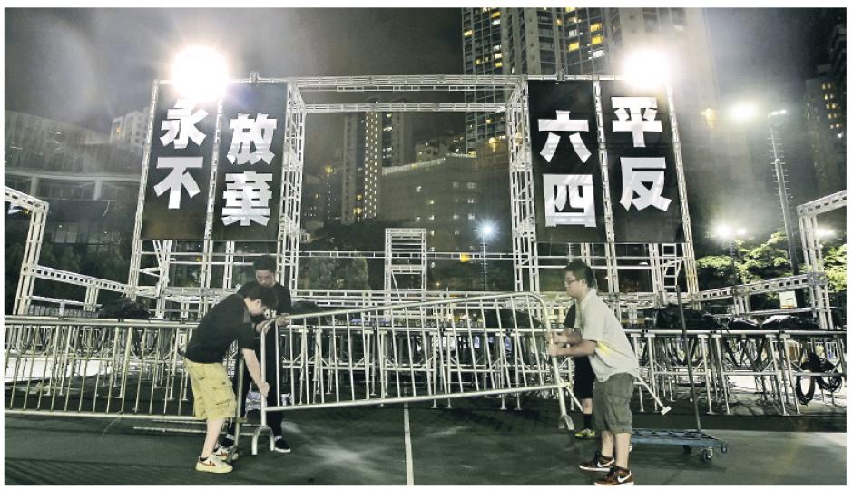 支聯會昨晚在維園為今晚的六四燭光晚會作準備,主舞台掛上了「平反六四,永不放棄」的巨型標語,而非早前備受爭議的「愛國愛民」口號。(李澤彤攝)在北京木樨地,公安拍攝正在街上行走的記者,並要求檢查證件。(明報記者攝) 支聯會昨晚在維園為今晚的六四燭光晚會作準備,主舞台掛上了「平反六四,永不放棄」的巨型標語,而非早前備受爭議的「愛國愛民」口號。(李澤彤攝)在北京木樨地,公安拍攝正在街上行走的記者,並要求檢查證件。(明報記者攝)