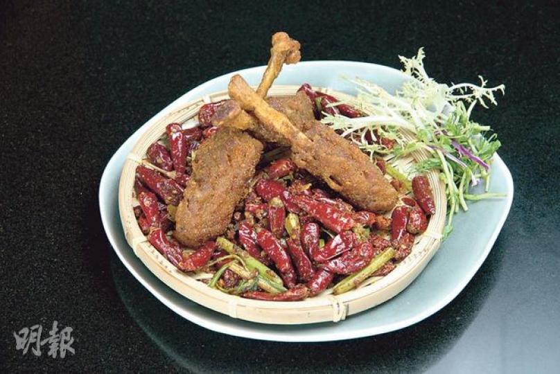 （前）重慶辣子雞 $215（Qi）先把鮮嫩雞扒慢煮10分鐘，保持肉質軟滑，再炸至酥香，並與十多種麻辣料快炒，雞扒吸盡香料精華，充滿麻辣香。（後）豆酥魚 $190（Qi）把桂花魚炸香後，用乾花椒、豆瓣醬等香料略炒，令魚肉滲滿辣味，肉嫩鮮甜。（黃志東攝）
